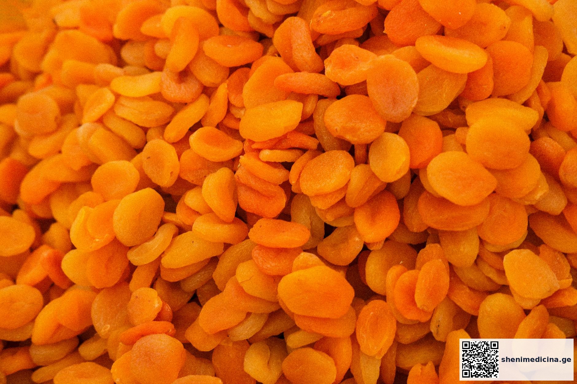 Close-up of bright orange dried apricots piled together in a heap.