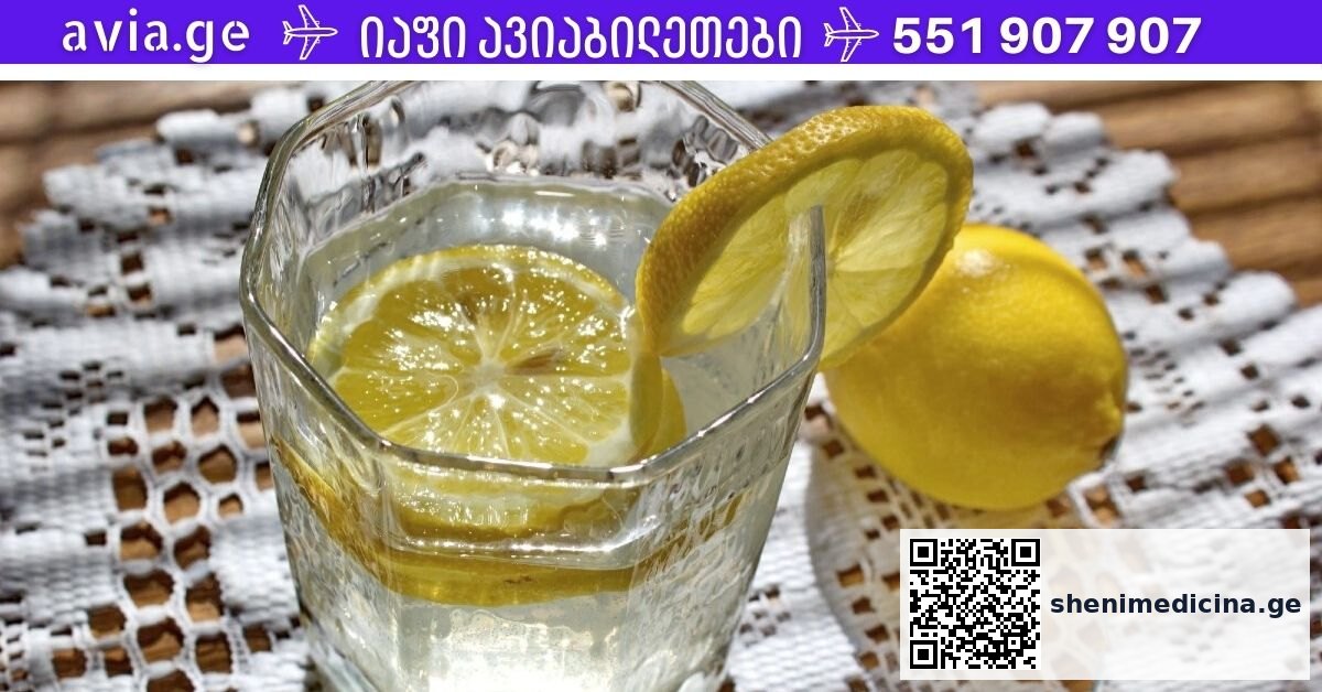 ლიმონიანი წყალი მინის ჭიქაში ახალი ლიმონებით